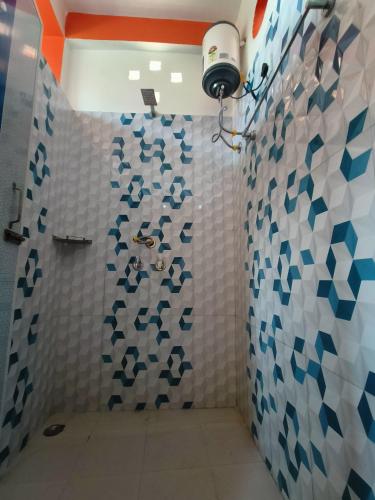 a bathroom with a shower with blue and white tiles at Abhishek Homestay in Dum Duma