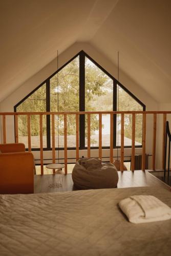 a bedroom with a bed and a large window at Cudomki nad jeziorem Krzywym in Piecki