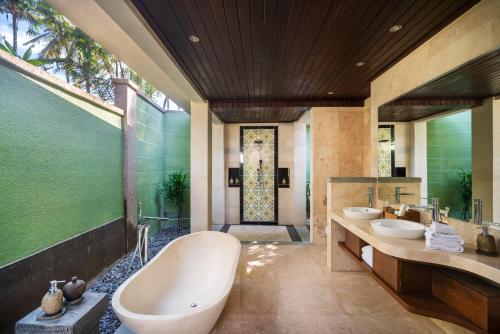 a bathroom with two sinks and a bath tub at Royal Arkara Villas by Arkamara in Ubud