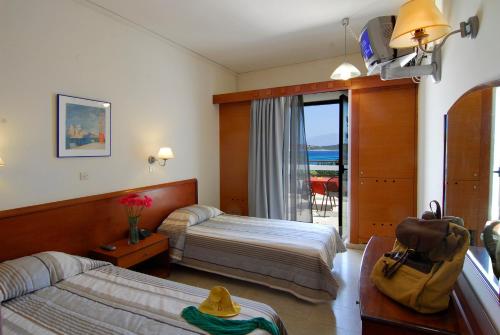 a hotel room with two beds and a balcony at Lato hotel in Agios Nikolaos