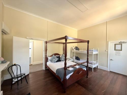 a bedroom with a canopy bed and a chair at Imperial Homestead in York