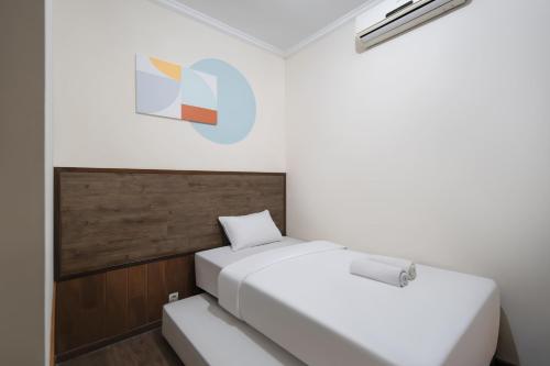 two beds in a room with a sign on the wall at Cove Casavanda in Serpong