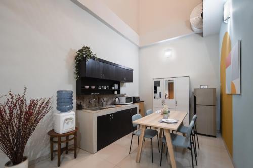 a kitchen with a table and chairs and a refrigerator at Cove Casavanda in Serpong
