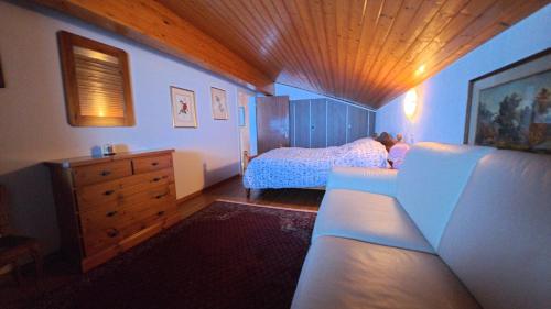 a bedroom with a bed and a dresser at Chalet Rezia in Savognin