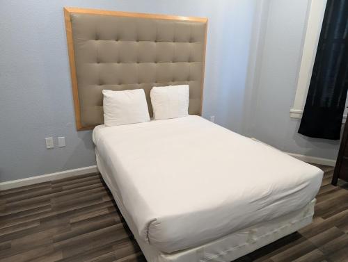 a white bed with a headboard in a room at Winsor Hotel in San Francisco