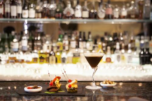 a drink and some food on a counter in a bar at Sofitel Beirut Le Gabriel in Beirut