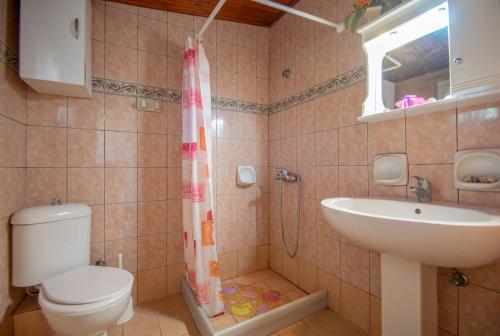 a bathroom with a toilet and a sink at Dora's Beach Cottages in Planos