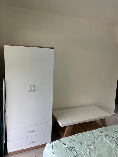 a bedroom with a white cabinet next to a bed at Honey Lodge in Punaauia
