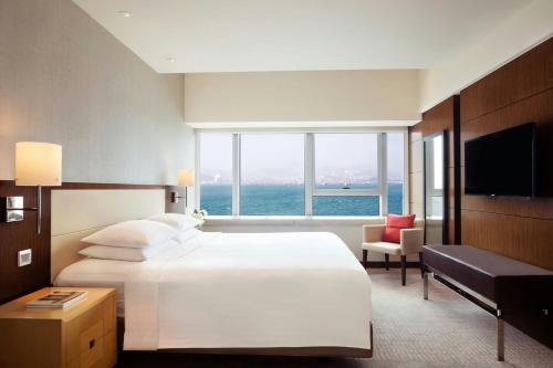 a bedroom with a large bed and a large window at Courtyard by Marriott Hong Kong in Hong Kong