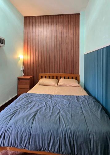 a bedroom with a large bed with a wooden headboard at JaiSabai Homestay in Mae Ai
