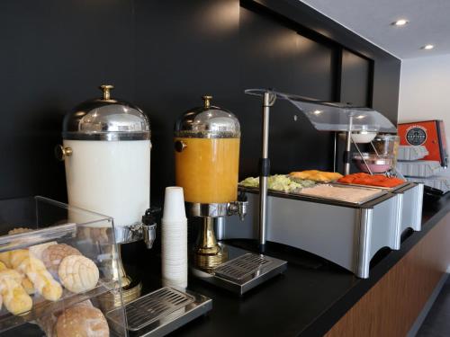 a counter with a food bar with a blender and bread at City Express by Marriott Tepotzotlán in Tepotzotlán