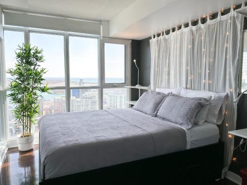 a bedroom with a bed and a large window at CityPlace Lofts Free Parking in Toronto