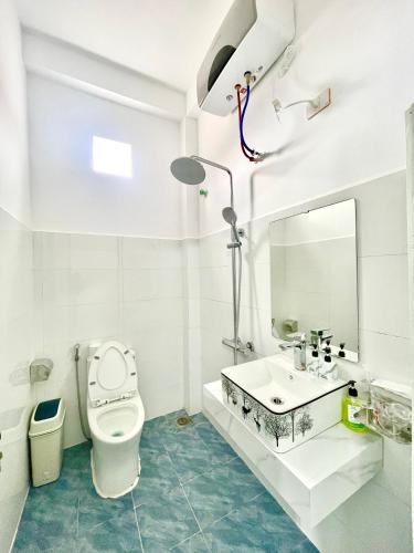 a bathroom with a toilet and a sink and a mirror at Nhà Nghỉ Mũi Giày in Mù Cang Chải