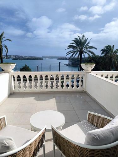 a balcony with tables and chairs and a view of the water at Senator Port Mahon in Mahón
