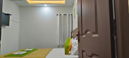 a small room with a bed and a shower at Hotel Royal Green Inn in Chennai