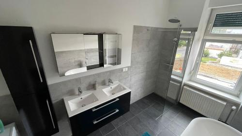 a bathroom with a sink and a mirror and a shower at Junior Suite Apartment Eleven in Graz