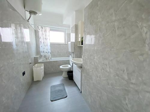a white bathroom with a sink and a toilet at Giulia Home appartamento per 6 persone in Monfalcone