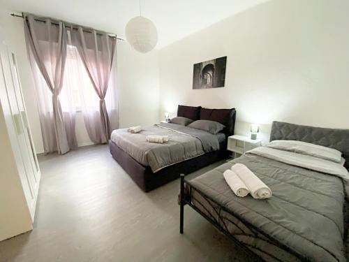 a bedroom with two beds and a couch at Giulia Home appartamento per 6 persone in Monfalcone