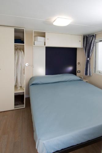 a small bedroom with a bed and a closet at Camping Parisi in Baveno
