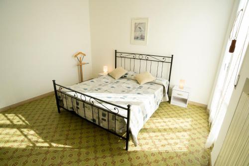 a bedroom with a black bed with a green carpet at Trilocale centrale e a due passi dal mare con posto auto privato in Marcelli
