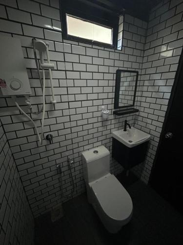 a bathroom with a toilet and a sink at Tiny House in Kuala Terengganu