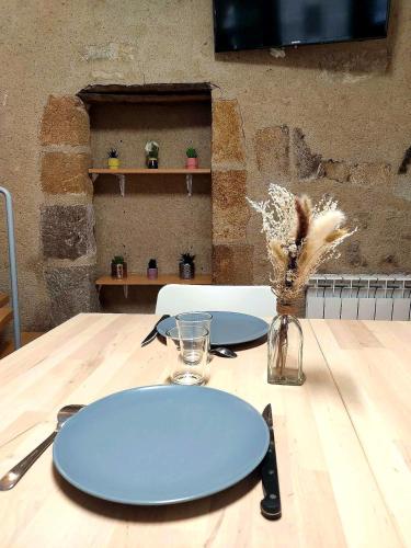 a wooden table with a blue plate on top of it at Le Nid Comtois in Vic-le-Comte