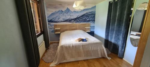 a room with a bed with a mountain mural on the wall at Villa Virtala Lohja in Lohja