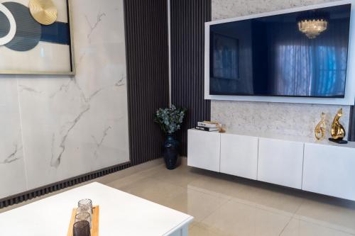 a living room with a tv on a wall at Casa familiar con piscina y cerca de la playa in La Belleza