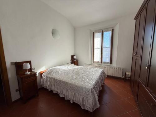 a white bedroom with a bed and a window at Molinella Appartamento Amelia & Carlo in Molinella