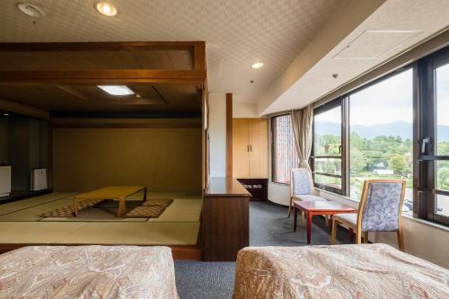 a room with two beds and a large window at Shiki-no-Yado Fujisan in Fujikawaguchiko