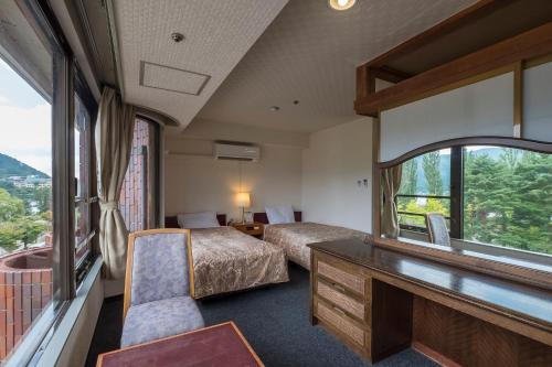 a room with two beds and a desk in a train at Shiki-no-Yado Fujisan in Fujikawaguchiko