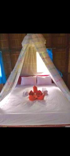 a bed with red flowers on top of it at Napoleon Homestay Raja Ampat in Poelau Mansoear