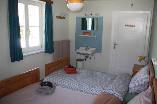 a small bedroom with a bed and a sink at Pension Fernsicht in Außerteuchen