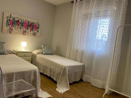 a bedroom with two twin beds and a window at Casa Costa Atlantica in Costa Ballena
