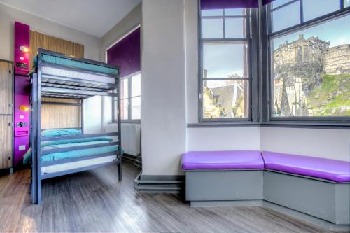 ein Zimmer mit lila Etagenbetten und einem Fenster in der Unterkunft Kick Ass Grassmarket (18+) in Edinburgh