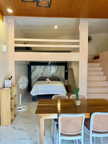 a bedroom with a bed and a table and chairs at Violegre Homestay - KABLON in General Luna