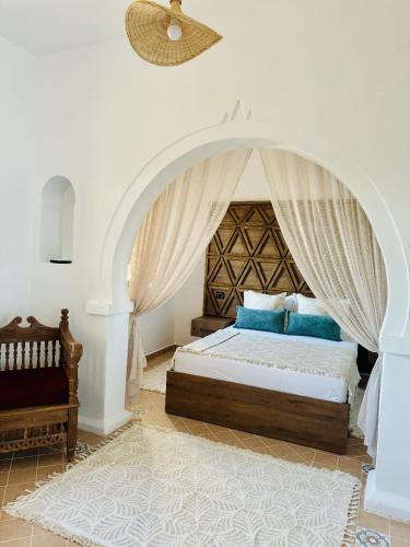 a bedroom with a bed with a canopy at Dar Sofien Erriadh Djerba in Erriadh