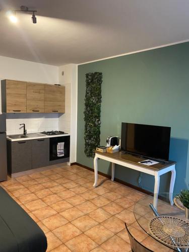 a living room with a table and a kitchen at Appartamento ONE in Novara