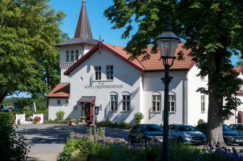 a white building with a church with a steeple at Hotel Frederiksminde in Præstø