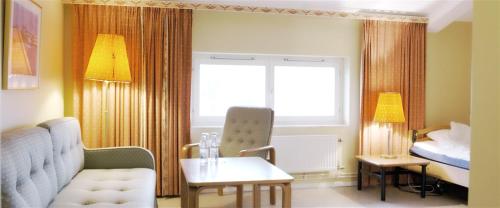 ein Hotelzimmer mit Sofa und Bett in der Unterkunft Valjeviken in Sölvesborg
