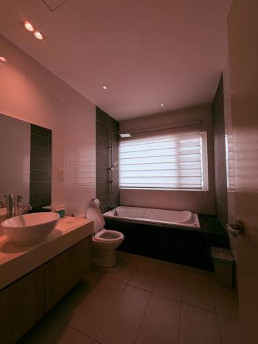 a bathroom with a tub and a sink and a toilet at Poshpack Skyline Hostel in Kuala Lumpur