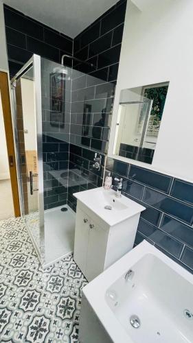 a bathroom with a sink and a shower and a toilet at Grass Court Terrace - walking distance from Wimbledon Championships in London