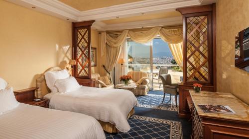a hotel room with two beds and a balcony at Rome Cavalieri, A Waldorf Astoria Hotel in Rome