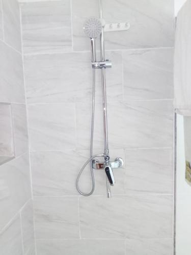 a shower with a shower head in a bathroom at Nhambavale Niara House in Chidenguele