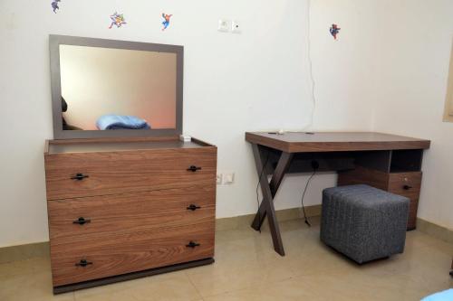 sypialnia z komodą, biurkiem i lustrem w obiekcie Oasis de l'Emergence w mieście Dakar