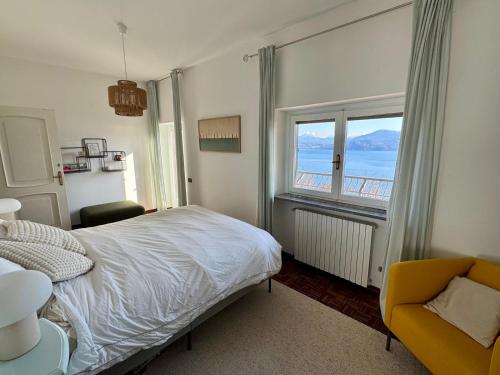 a bedroom with a bed and a window and a chair at Raggio di Sole Villa in Oggebbio