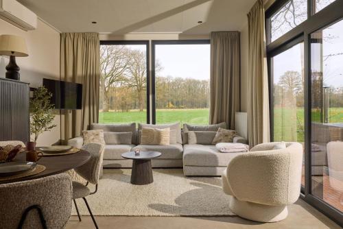 a living room with a couch and chairs and a table at Slow Living bij Mölke x Wellnesslodges in Zuna