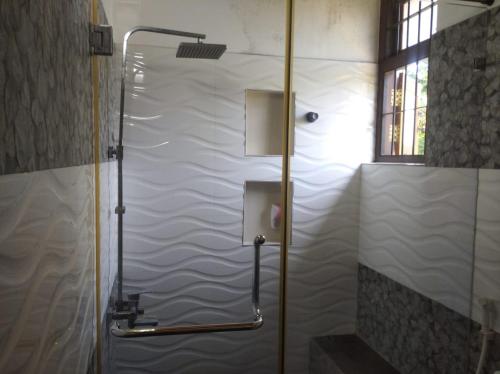 a shower with a glass door in a bathroom at Negombo New Villa in Negombo