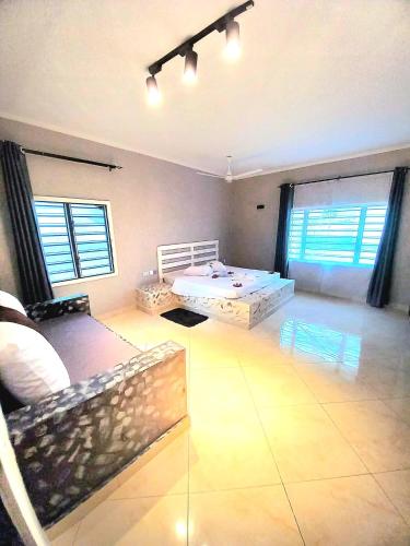 a living room with a bed and a room with windows at Villa SunShine exclusive in Watamu