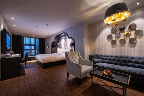 a hotel room with a bed and a couch at Orange Crystal Hotel Nanjing Museum in Nanjing
